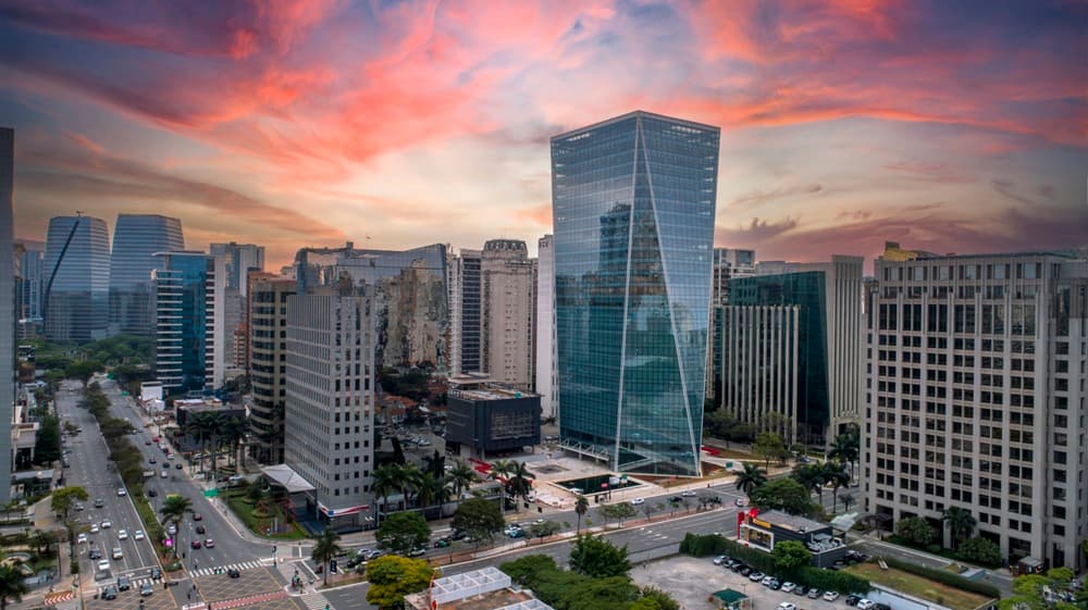 Imagem mostra uma cidade grande com vários prédios que refletem a cidade