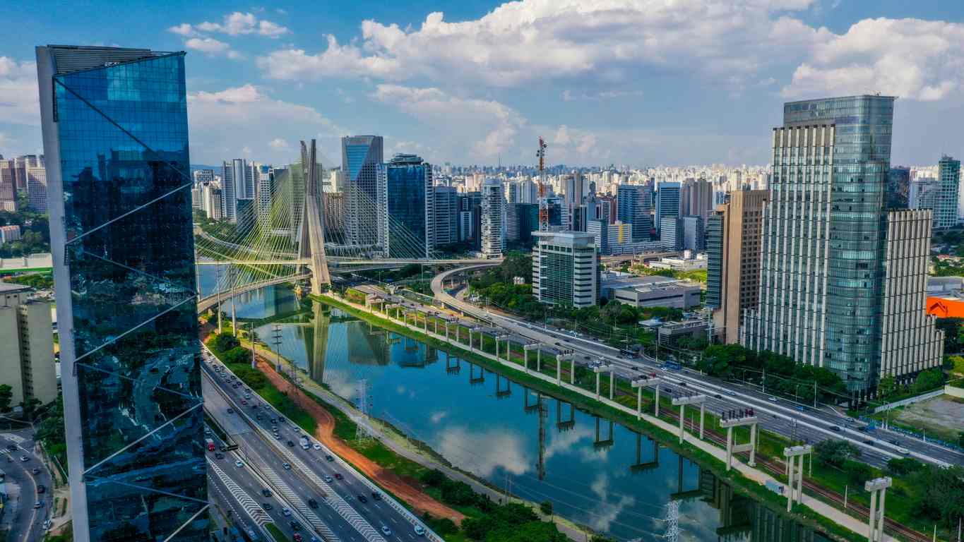 A imagem mostra o rio pinheiros, cercado por prédios altos e modernos.